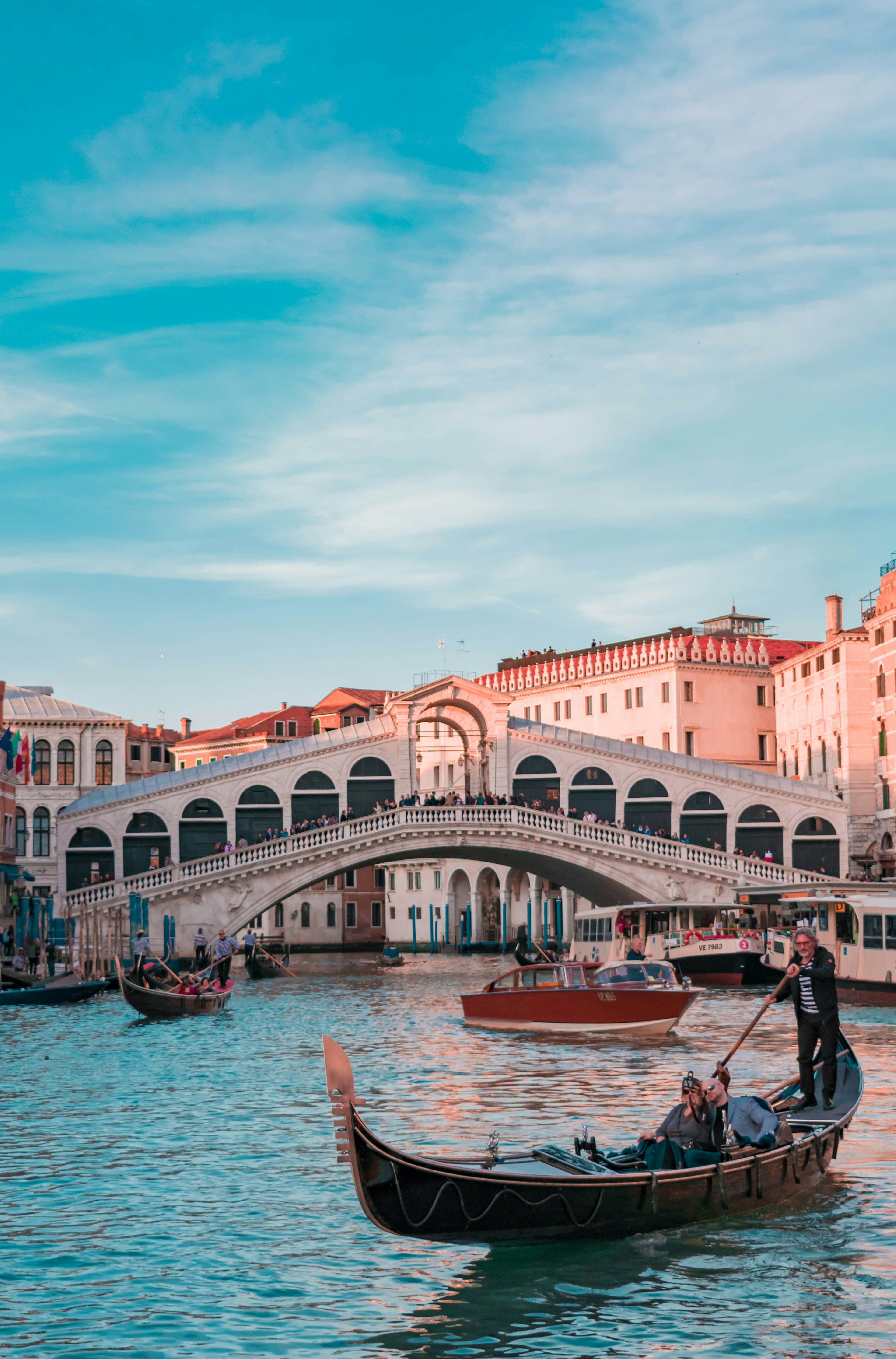 Venice Grand Canal Gondola Ride - Iconic stone Rialto Bridge spanning over the bustling Grand Canal in Venice Italy