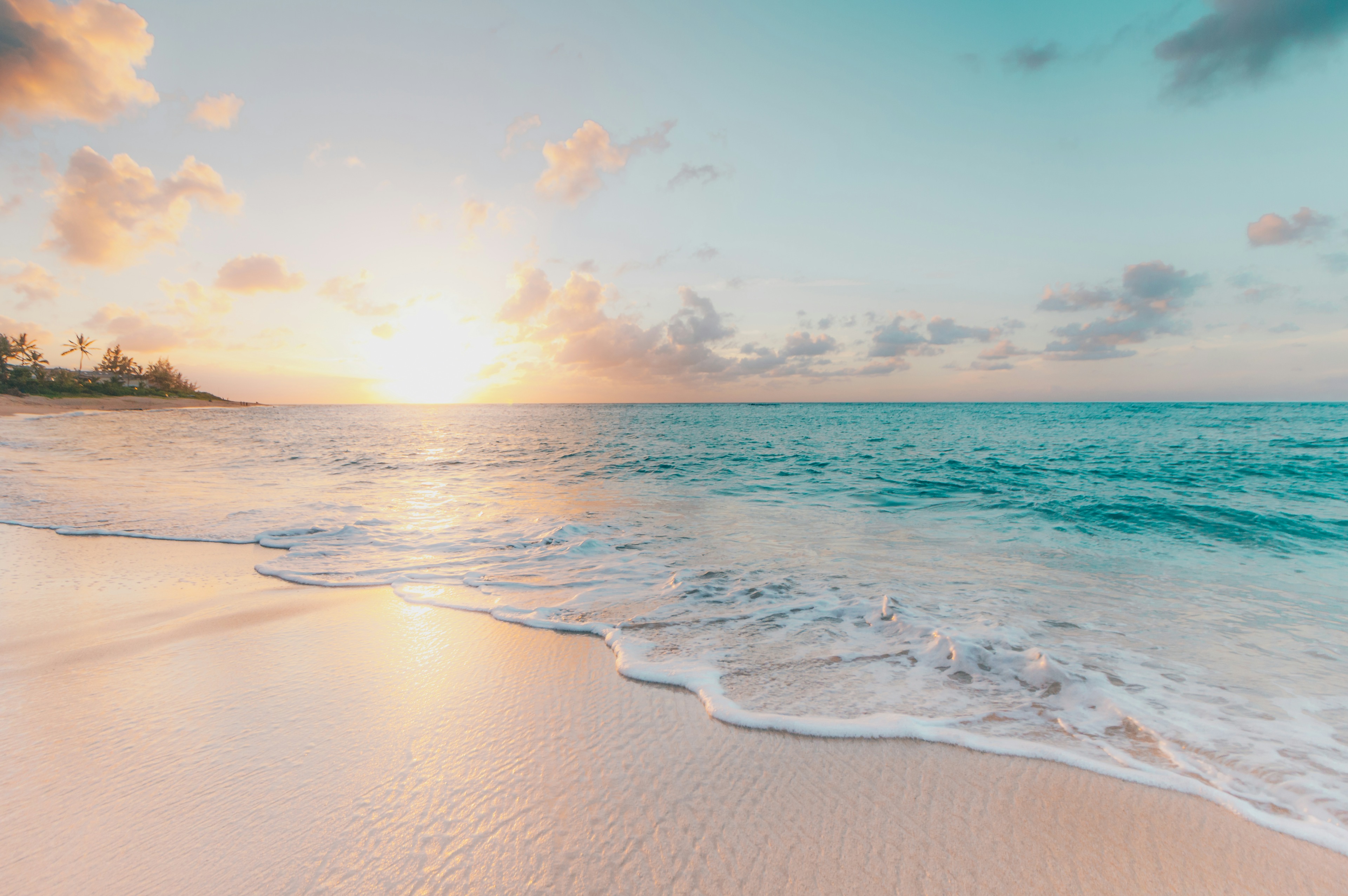 Maldives Luxury Catamaran Tour - Tropical sunset casting pink and gold reflections over white sand beach in the Maldives